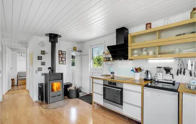 a kitchen with a stove and a fireplace at 4 Bedroom Stunning Home In Thyholm in Thyholm