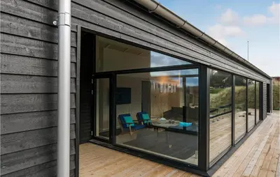 an extension to a house with sliding glass doors at Cozy Home In Blokhus With Kitchen in Blokhus