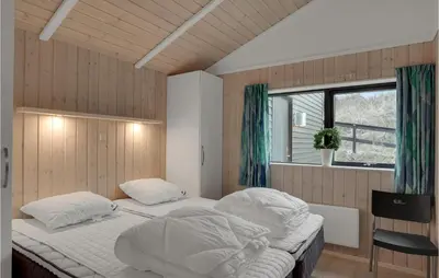 a bedroom with two beds and a window at Cozy Home In Blokhus With Kitchen in Blokhus
