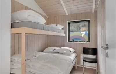 a bedroom with a bunk bed and a desk at Cozy Home In Blokhus With Kitchen in Blokhus