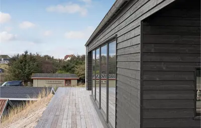 a building with glass windows on the side of it at Cozy Home In Blokhus With Kitchen in Blokhus