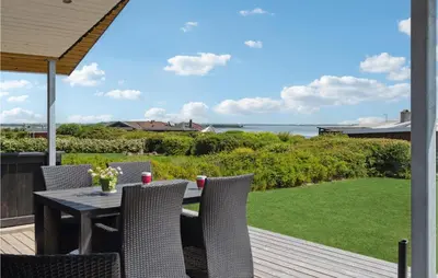 a table and chairs on a deck with a view of the ocean at 3 Bedroom Nice Home In Hurup Thy in Doverodde