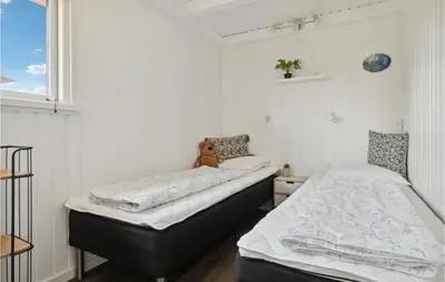 two beds in a bedroom with a teddy bear sitting on top at 3 Bedroom Nice Home In Hurup Thy in Doverodde