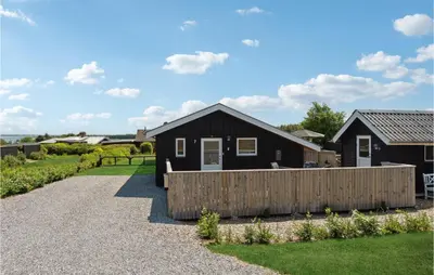 a black house with a wooden fence in front of it at 3 Bedroom Nice Home In Hurup Thy in Doverodde
