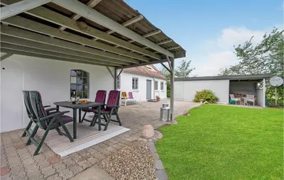 a patio with a table and chairs under a pergola at 1 Bedroom Beautiful Home In Roslev in Roslev