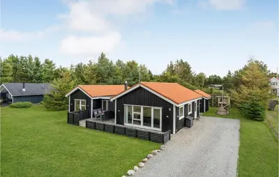 a black cabin with an orange roof on a yard at Stunning Home In Løgstør With Wifi in Løgstør