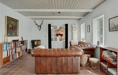 a living room with two leather couches and books at Lovely Home In Aabybro With Kitchen in Åbybro