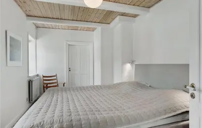 a bedroom with a white bed with a wooden ceiling at Lovely Home In Aabybro With Kitchen in Åbybro