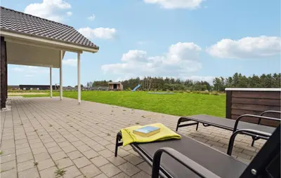 a patio with a table and benches and a playground at Stunning Home In Spøttrup With Sauna in Spottrup
