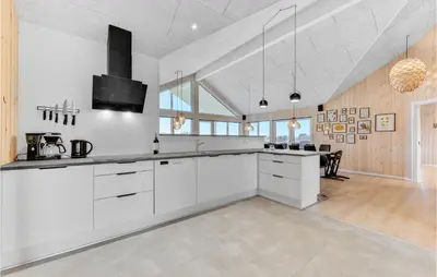 a kitchen with white cabinets and a dining room at Stunning Home In Spøttrup With Sauna in Spottrup