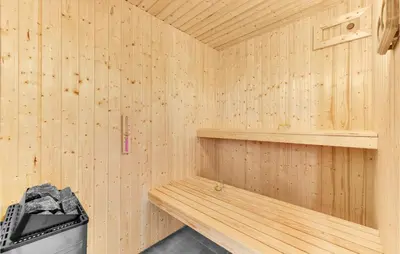 a wooden sauna with a bench and a trash can at Stunning Home In Spøttrup With Sauna in Spottrup