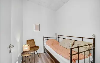 a bedroom with a metal bunk bed and a chair at Amazing Home In Spøttrup With Wifi in Spottrup