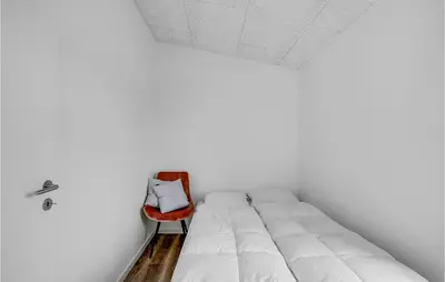 a bedroom with a white bed and a red chair at Amazing Home In Spøttrup With Wifi in Spottrup
