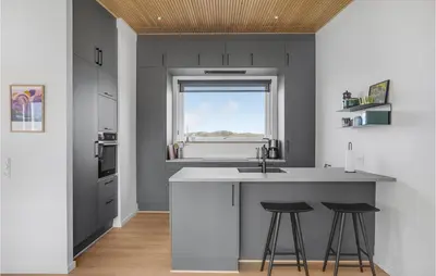a kitchen with a sink and two bar stools at 3 Bedroom Lovely Home In Fjerritslev in Fjerritslev