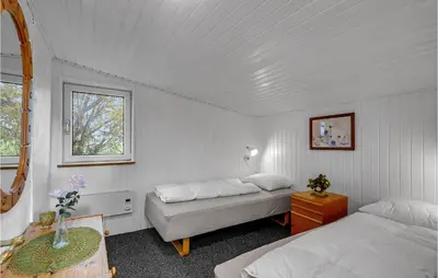 a bedroom with two beds and a table and a window at Lovely Home In Hurup Thy With Wifi in Gettrup