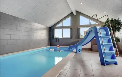 a swimming pool with a blue slide in a room at Cozy Home In Spøttrup With Wifi in Spottrup