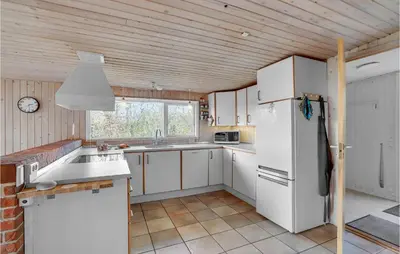a kitchen with white cabinets and a white refrigerator at Awesome Home In Roslev With Kitchen in Roslev