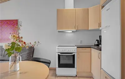 a kitchen with a table and a stove and cabinets at Beautiful Home In Pandrup With Wifi in Pandrup