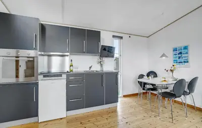 a kitchen with gray cabinets and a table with chairs at 1 Bedroom Gorgeous Home In Vestervig in Vestervig