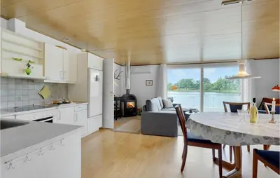 a kitchen and living room with a table and a dining room at 2 Bedroom Awesome Home In Vemb in Vemb