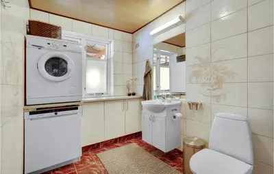 a bathroom with a washing machine and a toilet at 2 Bedroom Awesome Home In Vemb in Vemb