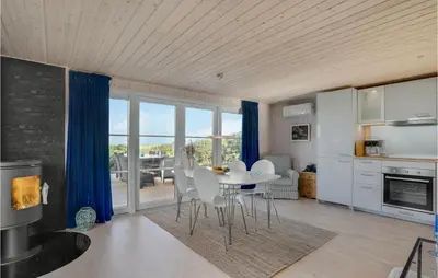 a kitchen and living room with a table and chairs at Lovely Home In Løgstør With Kitchen in Løgstør