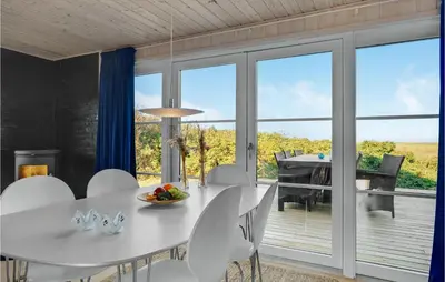 a dining room with a white table and chairs at Lovely Home In Løgstør With Kitchen in Løgstør