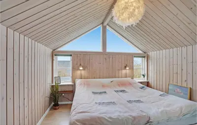a bedroom with a large bed in a room with a chandelier at Stunning Home In Lemvig With Wifi in Lemvig