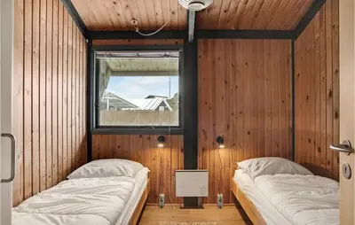 two beds in a room with wooden walls at 3 Bedroom Stunning Home In Blokhus in Blokhus