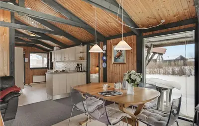 a kitchen and dining room with a table and chairs at 3 Bedroom Stunning Home In Blokhus in Blokhus