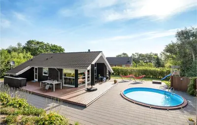 a wooden deck with a swimming pool and a house at Gorgeous Home In Vemb in Vemb