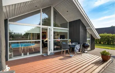 a house with a deck with a table and chairs at Gorgeous Home In Vemb in Vemb