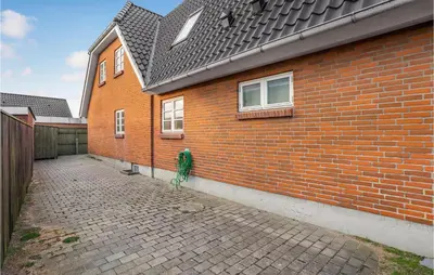 a building with a brick wall and a brick driveway at Nice Home In Thyborøn With Wifi in Thyborøn