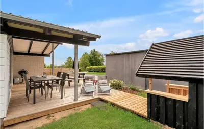 a wooden deck with a table and chairs at 3 Bedroom Lovely Home In Spøttrup in Spottrup