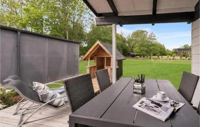 a patio with a table and chairs and a dog house at 3 Bedroom Lovely Home In Spøttrup in Spottrup