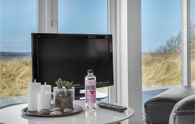a living room with a television and a table with a bottle of water at Stunning Home In Højslev With Kitchen in Højslev