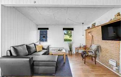 a living room with a couch and a table at Cozy Home In Vesløs With House Sea View in Øsløs