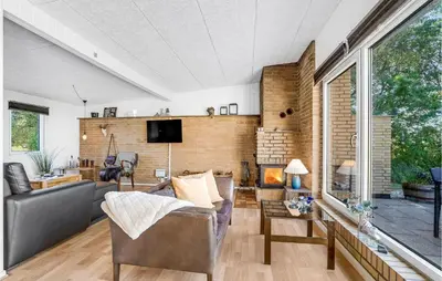 a living room with a couch and a fireplace at Cozy Home In Vesløs With House Sea View in Øsløs