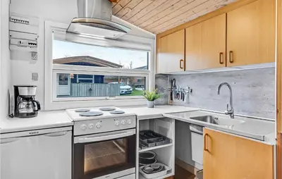 a kitchen with a stove and a sink and a window at Stunning Home In Hanstholm in Hanstholm