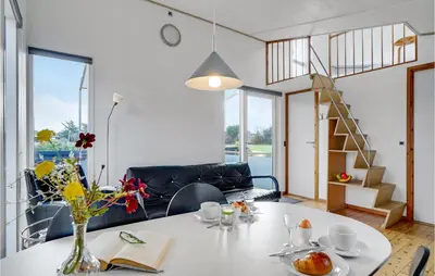 a living room with a table with a vase of flowers at Gorgeous Home In Vestervig With Kitchen in Vestervig