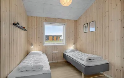 two beds in a room with a window at Beautiful Home In Løgstrup With Kitchen in Løgstrup