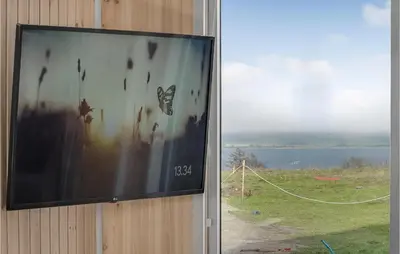 a flat screen tv hanging on a wall next to a window at Beautiful Home In Løgstrup With Kitchen in Løgstrup