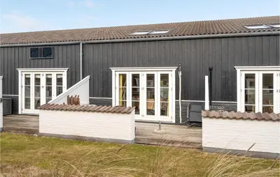 a gray house with white doors and windows at Agger Havn Feriecenter in Vestervig