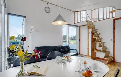a living room with a table with a vase of flowers at Cozy Home In Vestervig With Wifi in Vestervig