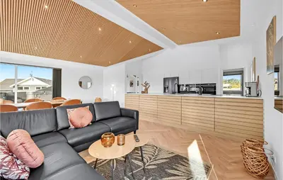 a living room with a black couch and a kitchen at Awesome Home In Harboøre With Kitchen in Harboør