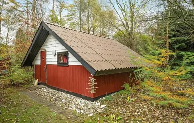 a red and white shed in the woods at Gorgeous Home In Roslev With Wifi in Roslev