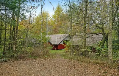 a red barn in the middle of the woods at Gorgeous Home In Roslev With Wifi in Roslev