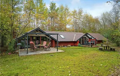 a red house with a deck and a table at Gorgeous Home In Roslev With Wifi in Roslev