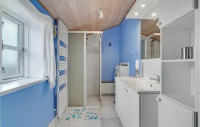 a bathroom with a white sink and a blue wall at Gorgeous Home In Lemvig With Wifi in Lemvig