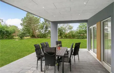 a patio with a table and chairs on it at Awesome Home In Nibe With Kitchen in Nibe